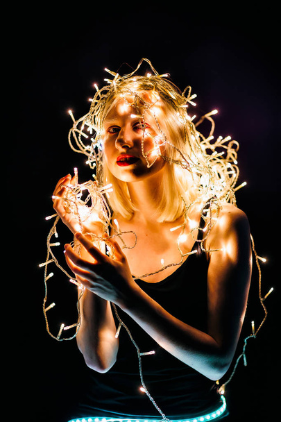 Blonde girl with electric garland on her head - Foto, immagini