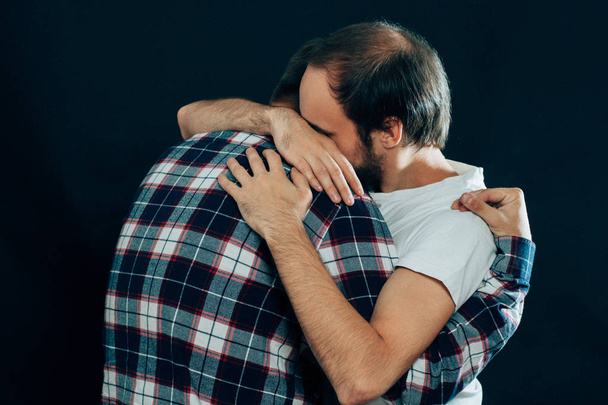 two guys hugging on a dark background - Foto, Imagem