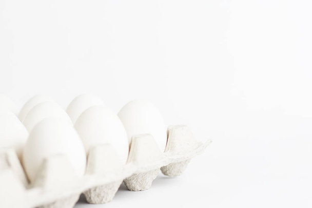 White chicken eggs in a paper tray on white background - Φωτογραφία, εικόνα