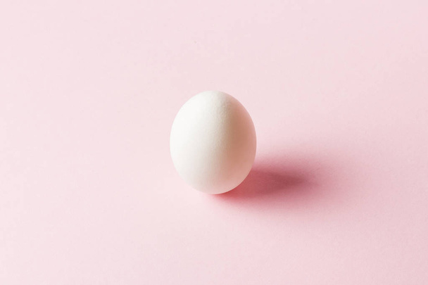 White Chicken Egg on a pink background. Minimalism. Side view - Foto, Imagem