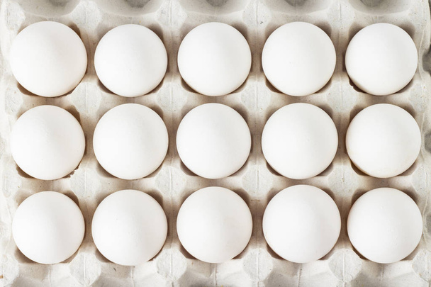Uova di pollo bianco in vassoio di carta su sfondo bianco. Posa piatta, vista dall'alto
 - Foto, immagini