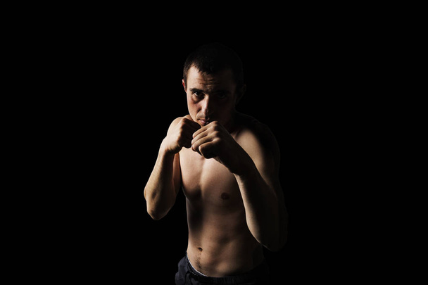Bir adam bir mücadele duruş, koyu arka plan. Dövüş sanatları kavramı, egzersiz - Fotoğraf, Görsel