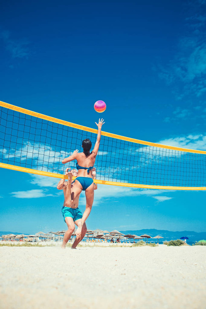 Summer vacation and travel on holiday in Miami. summer vacation of happy healthy couple lpaying volleyball on beach. - Φωτογραφία, εικόνα