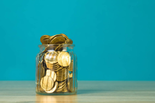 Coin money in the glass jar on table with green background, for  - 写真・画像