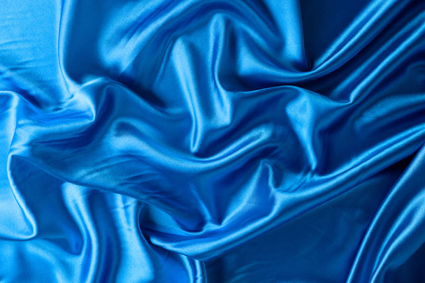 Hintergrund Textur, Muster. blauer Seidenstoff, zerknitterte Textur, die jedem Stoffdesign Interesse und Tiefe verleiht - Foto, Bild