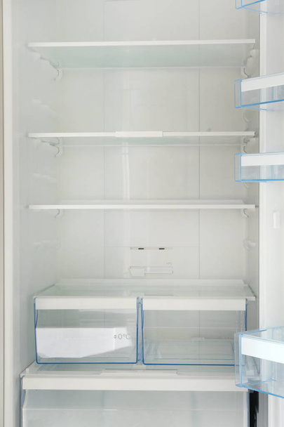 Пустые белые полки в холодильнике. Концепция диеты и голода. Вертикальное изображение
. - Фото, изображение