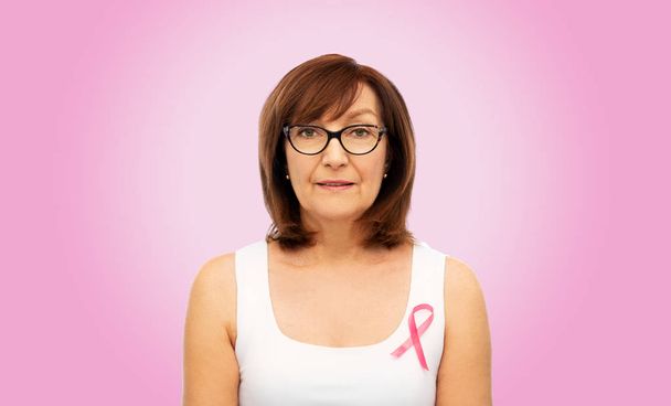 old woman with pink breast cancer awareness ribbon - Foto, immagini