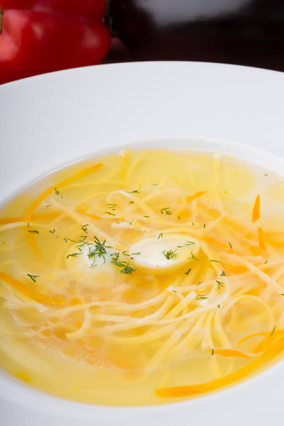 Yellow noodle soup served with quail egg in white plate - Foto, Imagem