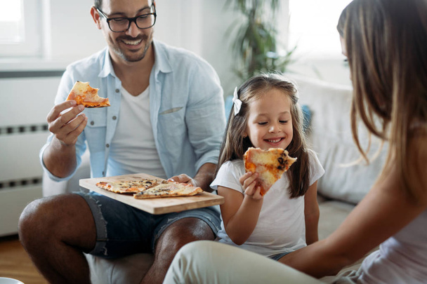 Portrait of happy family sharing pizza together at home - Foto, imagen