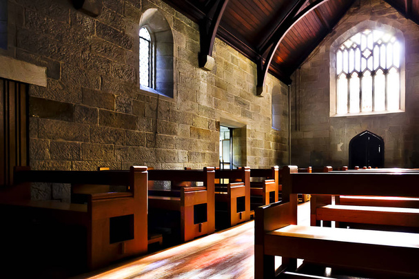 Old church architecture with stone walls and wooden benches  - Photo, image