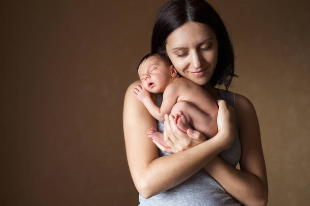 Young mother holding her newborn sleeping baby - Photo, Image