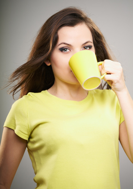 Attractive young woman in a yellow shirt. Woman drinking from a - Foto, Imagem