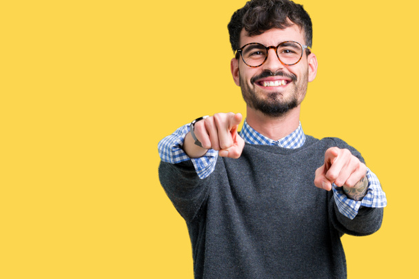 Young handsome smart man wearing glasses over isolated background Pointing to you and the camera with fingers, smiling positive and cheerful - Photo, Image