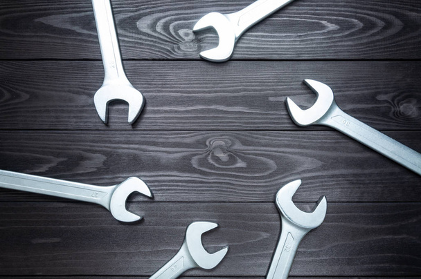 set of chromed wrenches on a dark wooden workbench. top view, copy space - Foto, Imagem