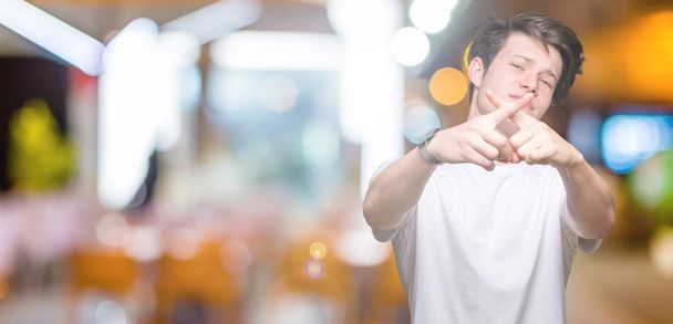 Joven hombre guapo vistiendo casual camiseta blanca sobre fondo aislado Expresión de rechazo cruzando dedos haciendo signo negativo
 - Foto, imagen