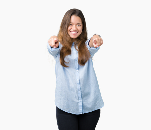 Jonge mooie brunette zakenvrouw over geïsoleerde achtergrond Pointing aan u en de camera met de vingers, positief en vrolijk lachend - Foto, afbeelding