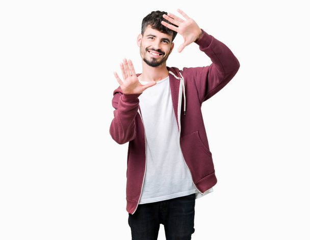 Young handsome man over isolated background Smiling doing frame using hands palms and fingers, camera perspective - Fotoğraf, Görsel