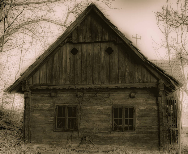 Monochroom zwart-wit beeld van een verlaten verloren oude houten hut in een mistige spookachtig landschap in surrealistische vintage Schilderstijl  - Foto, afbeelding