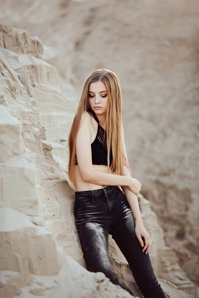 Retrato de una hermosa chica con el pelo largo en la arena en el desierto al atardecer
 - Foto, imagen
