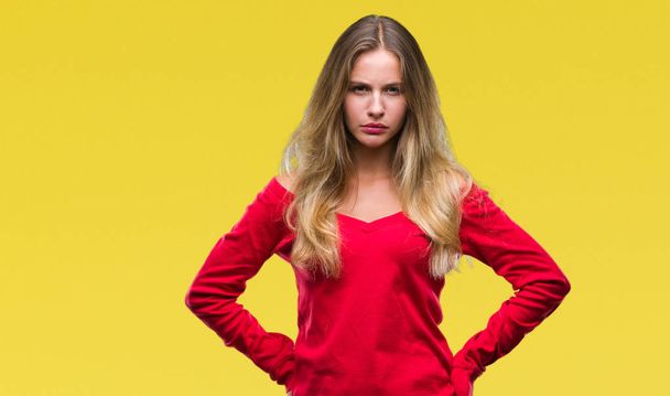 Νέοι όμορφη ξανθιά γυναίκα φορώντας κόκκινο πουλόβερ πάνω από απομονωμένες φόντο σκεπτικιστής και νευρικό, Συνοφρυωμένος αναστατωμένος εξαιτίας προβλήματος. Αρνητικό πρόσωπο. - Φωτογραφία, εικόνα