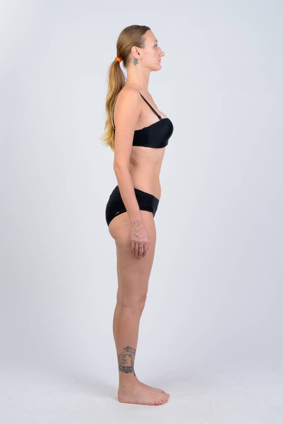 Full body shot profile view of blonde woman wearing bikini - Foto, Imagem