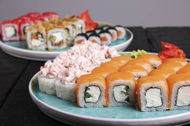 fresh   sushi rolls on the blue  plates on the table  - Photo, Image
