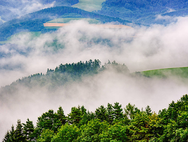 landschaftlich impressionistische Outdoor-Landschaft Natur Farbbild einer neblig geschichteten hügeligen ländlichen Landschaft mit Feldern, Wald und Nebel in Tälern - Foto, Bild