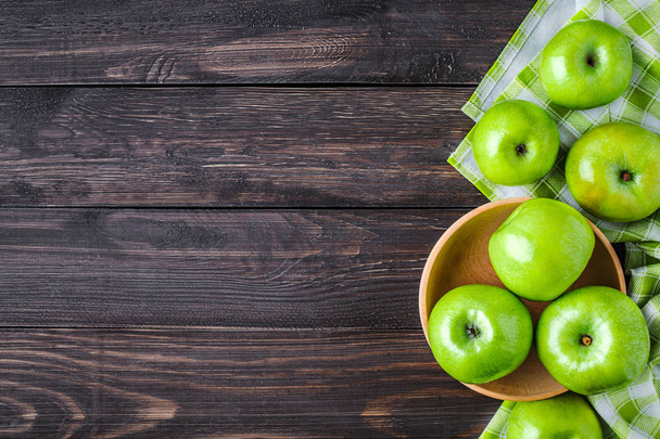 Ripe green apples and apple slices on old wooden background. Pla - Foto, afbeelding