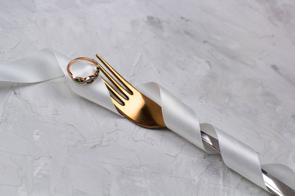 fork decorated with white satin ribbon for wedding  with golden ring - 写真・画像