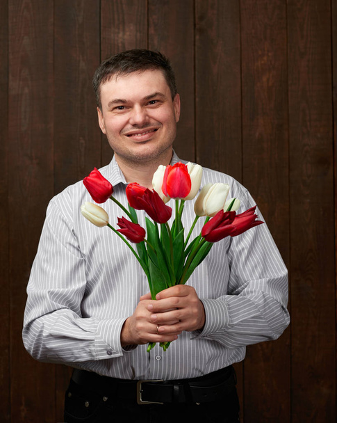 Man holds red flowers bouquet - Valokuva, kuva
