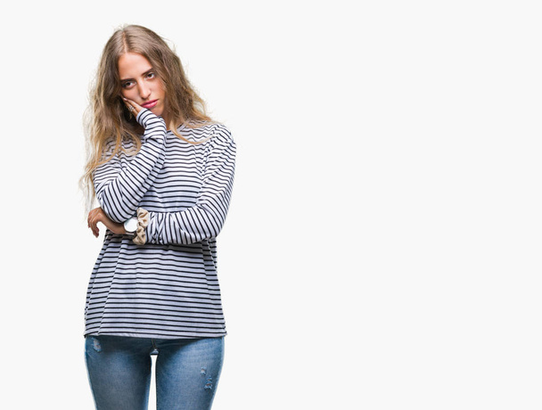 疲れていて、組んだ腕のうつ病問題にうんざりして孤立した背景を考えての上のストライプのセーターを着ている美しい若いブロンドの女性. - 写真・画像
