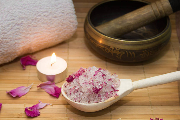 homemade body scrub from sea salt and rose petals and peony, Tibetan bowl,candle,pink towel on a straw Mat. Spa concept - Fotoğraf, Görsel