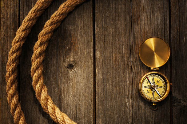 Antique compass and rope over wooden background - Photo, Image