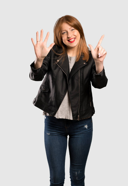 Jeune rousse femme comptant sept avec les doigts sur fond gris isolé
 - Photo, image