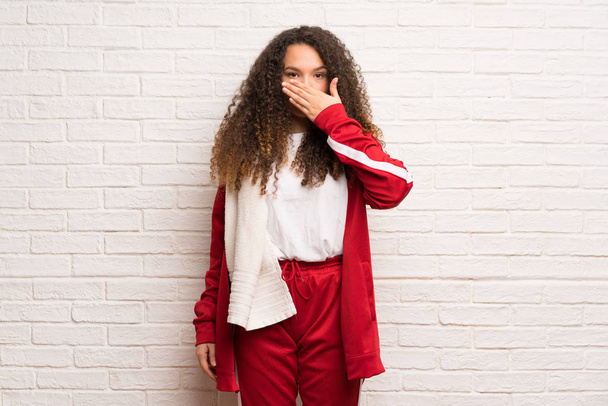 Teenager sport girl with curly hair covering mouth with hands for saying something inappropriate - Photo, Image