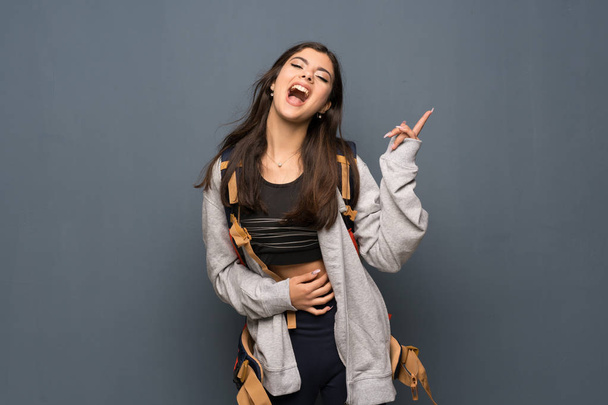 Teenager traveler girl over wall smiling a lot - Foto, Imagen