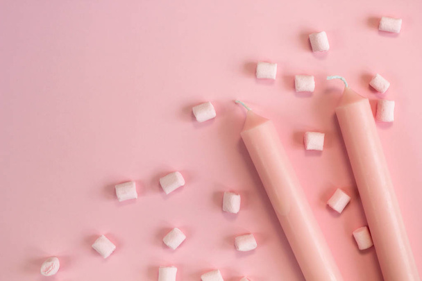 top view pink pastel candles and marshmallows on pink pastel background copy space - Foto, Imagen