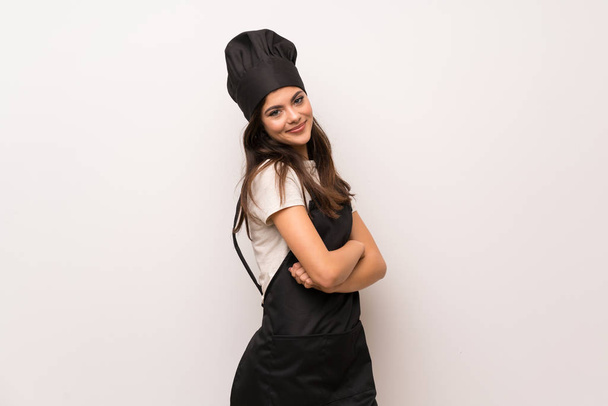Tiener chef-kok over de witte muur met gekruiste armen en Verheugen - Foto, afbeelding