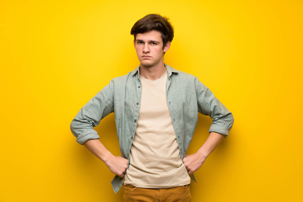 Adolescente homem sobre parede amarela com raiva
 - Foto, Imagem
