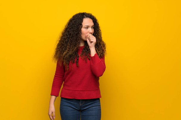 Menina adolescente com suéter vermelho sobre a parede amarela está sofrendo com tosse e se sentindo mal
 - Foto, Imagem
