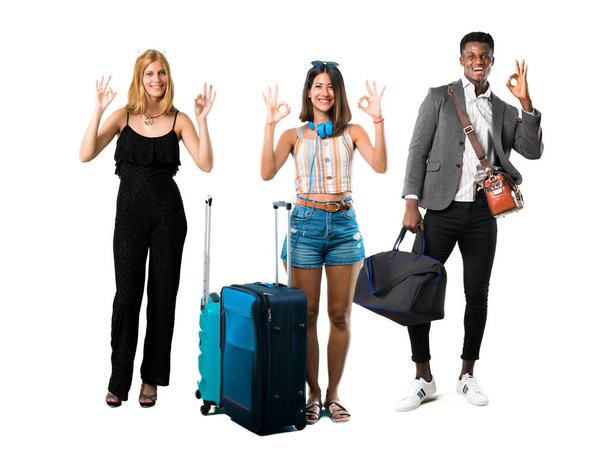Άτομα που ταξιδεύουν με βαλίτσες που εμφανίζουν ένα OK σύμβολο με δάχτυλα. - Φωτογραφία, εικόνα