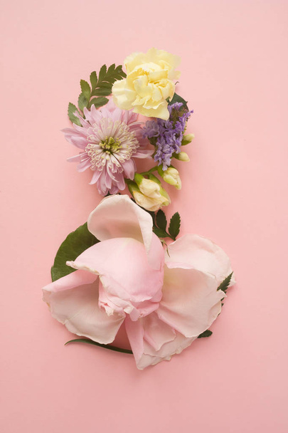 Figure 8 made of different flowers on pink background - Foto, Imagen