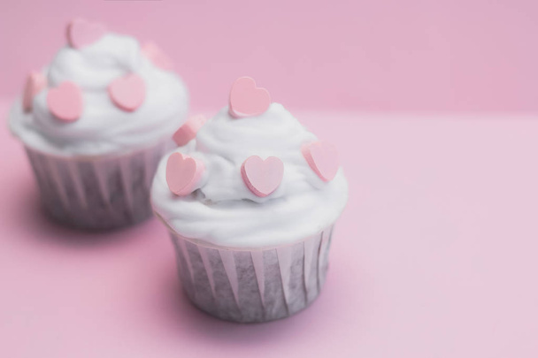 cute cupcakes decorated with pink hearts on a pink background - Foto, afbeelding