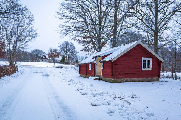 Paisaje de invierno con casa de madera roja en Suecia al amanecer
 - Foto, imagen