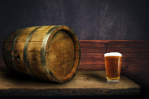 Дерев'яна бочка і келих пива на старому дубовому столі з дерева
. - Фото, зображення