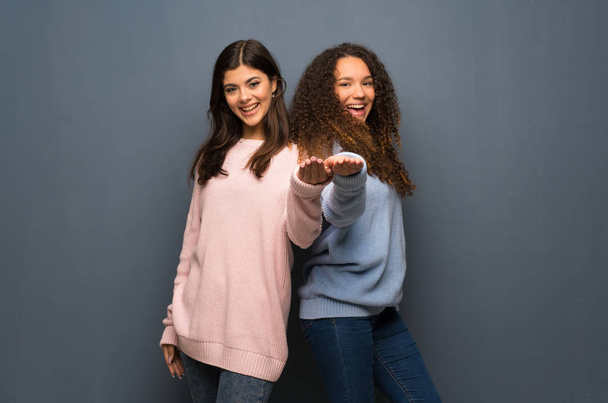 Amigos adolescentes sosteniendo espacio de copia imaginario en la palma de la mano para insertar un anuncio
 - Foto, imagen