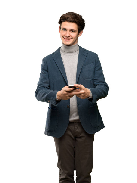 Homme adolescent à col roulé envoyant un message avec le mobile sur fond blanc isolé
 - Photo, image
