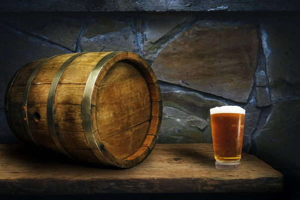 Canna di legno e bicchiere di birra su un vecchio tavolo di legno di quercia
. - Foto, immagini