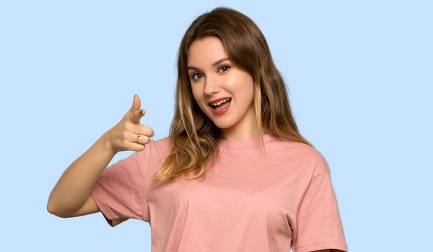 Teenager girl with pink sweater frustrated by a bad situation on isolated blue background - Photo, image