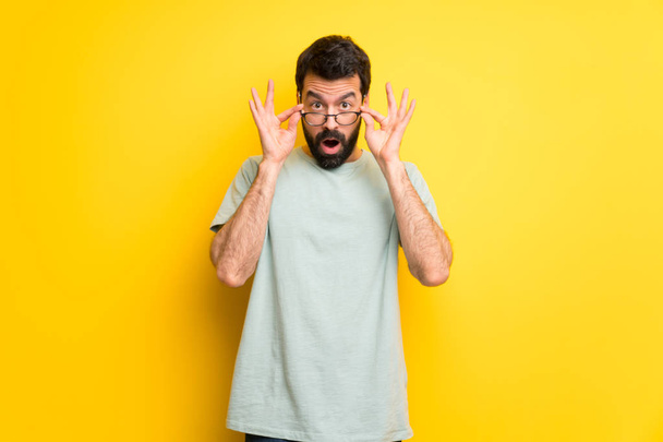 Man with beard and green shirt with glasses and surprised - Zdjęcie, obraz